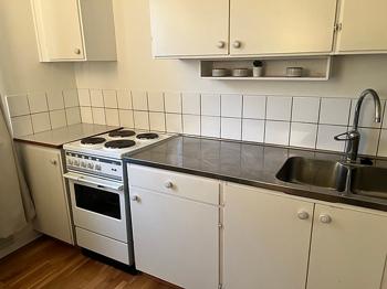 Köksskåp och bänkskiva i vitt med diskho och spis
