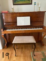 Akustiskt piano med pall i trä