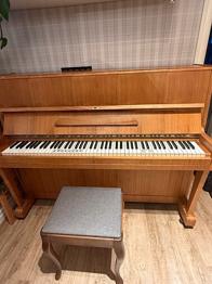 Akustiskt piano i trä skänkes