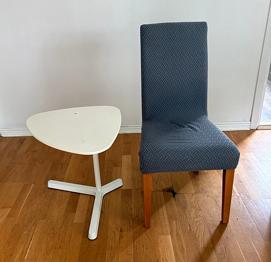 Stabil stol med överdrag och ett litet vitt avlastnings bord!