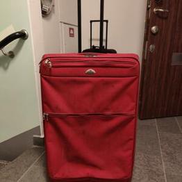 Röd stor Samsonite resväska på hjul